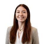 Marley Walker, Proposal Technical Writer at Leidos QTC Health Services, smiles at the camera in a professional headshot wearing a beige blazer over a white blouse against a clean white background.