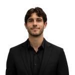 Michael Austin, Software Engineer at Leidos QTC Health Services, smiles at the camera in a professional headshot wearing a black blazer over a black collared shirt against a clean, plain background.