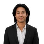 Timothy Chiu, Software Engineer at Leidos QTC Health Services, smiles at the camera in a professional headshot wearing a dark blazer over a white collared shirt against a clean, plain background.