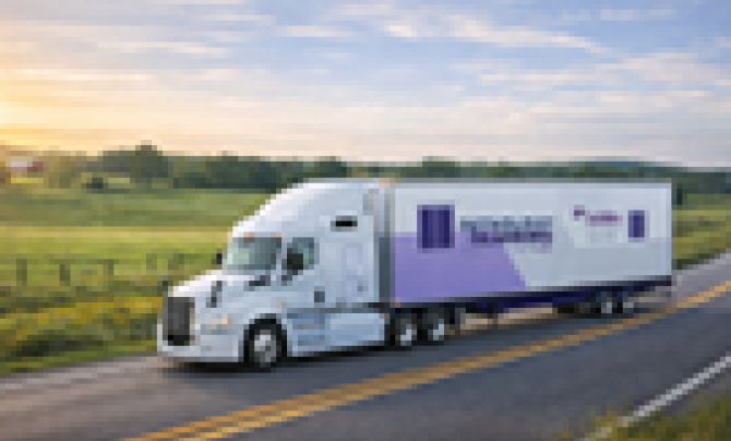 Scanvan truck driving down a rural road