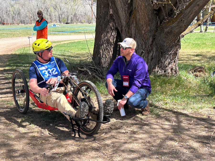Two people chatting while one person is on a bike