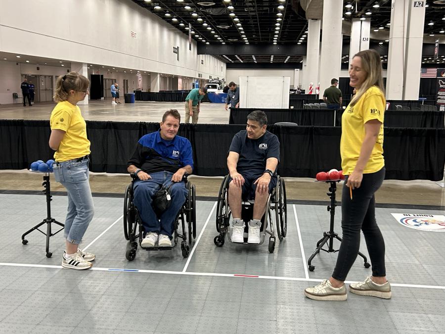 Angela Carrigan (right) standing with a fellow volunteer (left) and two athletes (center).