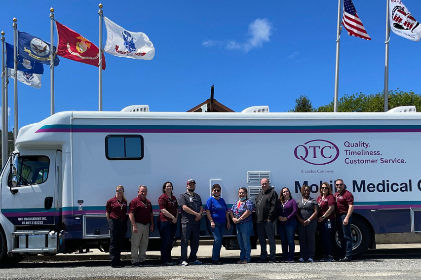 QTC team stands in front of Mobile Medical Clinic van.