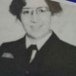 Black and white photo of woman in uniform and glasses