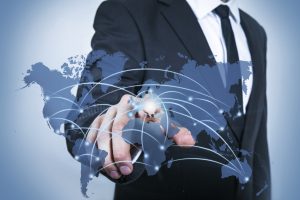 Chest of a man wearing suit and pointing at a graphic of the world's countries